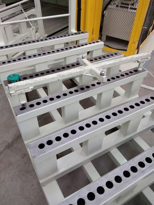 Una máquina está colocada encima de una paleta blanca con agujeros.