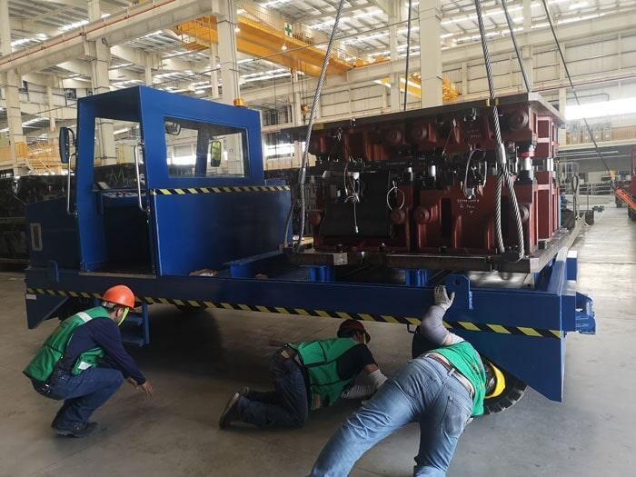 Dos hombres están trabajando en un equipo grande en una fábrica.
