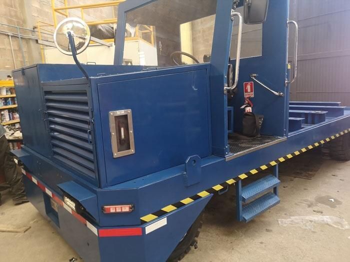 Un camión azul con escaleras está estacionado en un garaje.