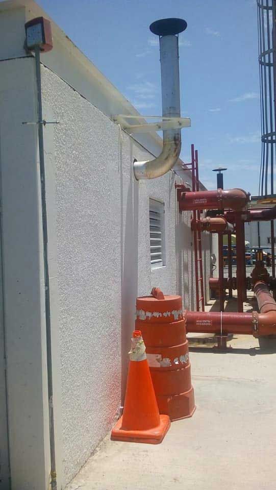 Un edificio blanco con conos y tuberías naranjas en los costados.