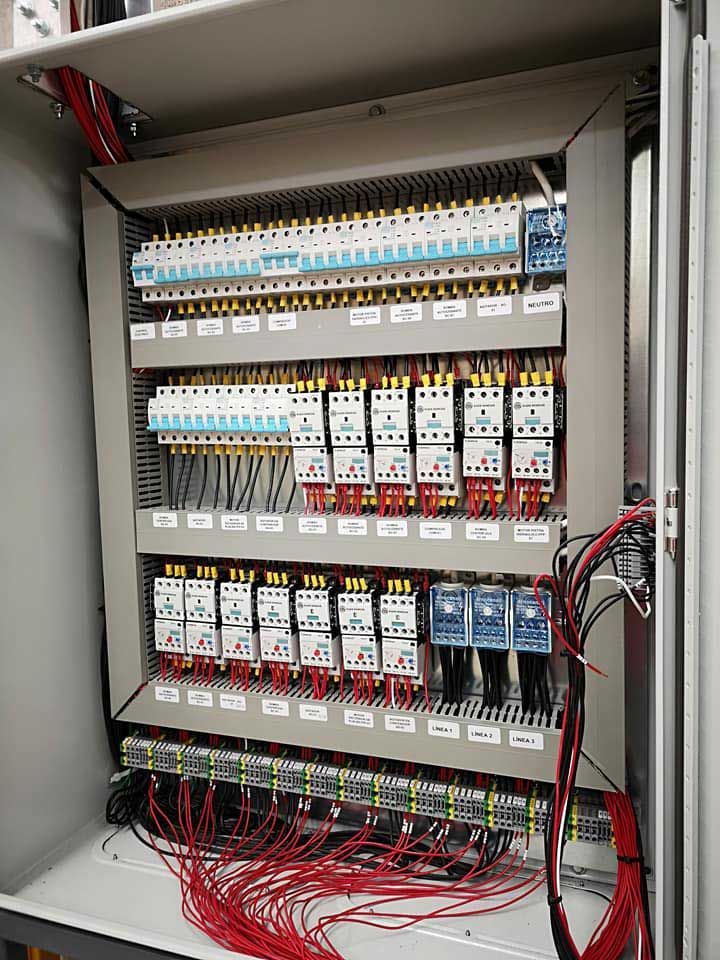 Un panel de control eléctrico con muchos cables que salen de él.