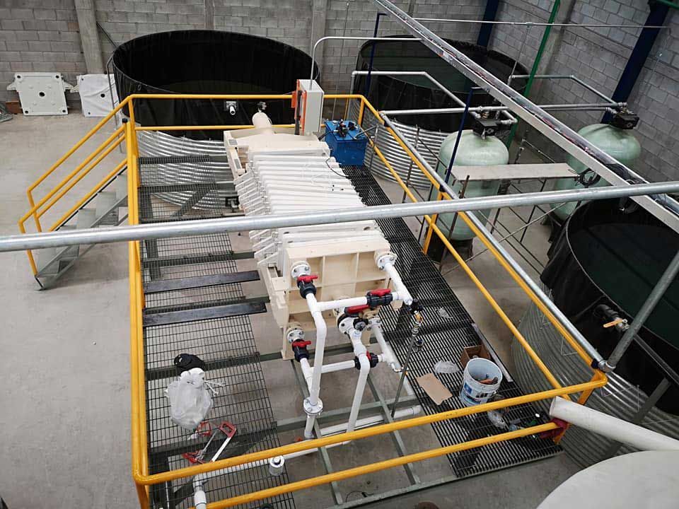 Una vista aérea de una máquina en una fábrica con una barandilla amarilla.