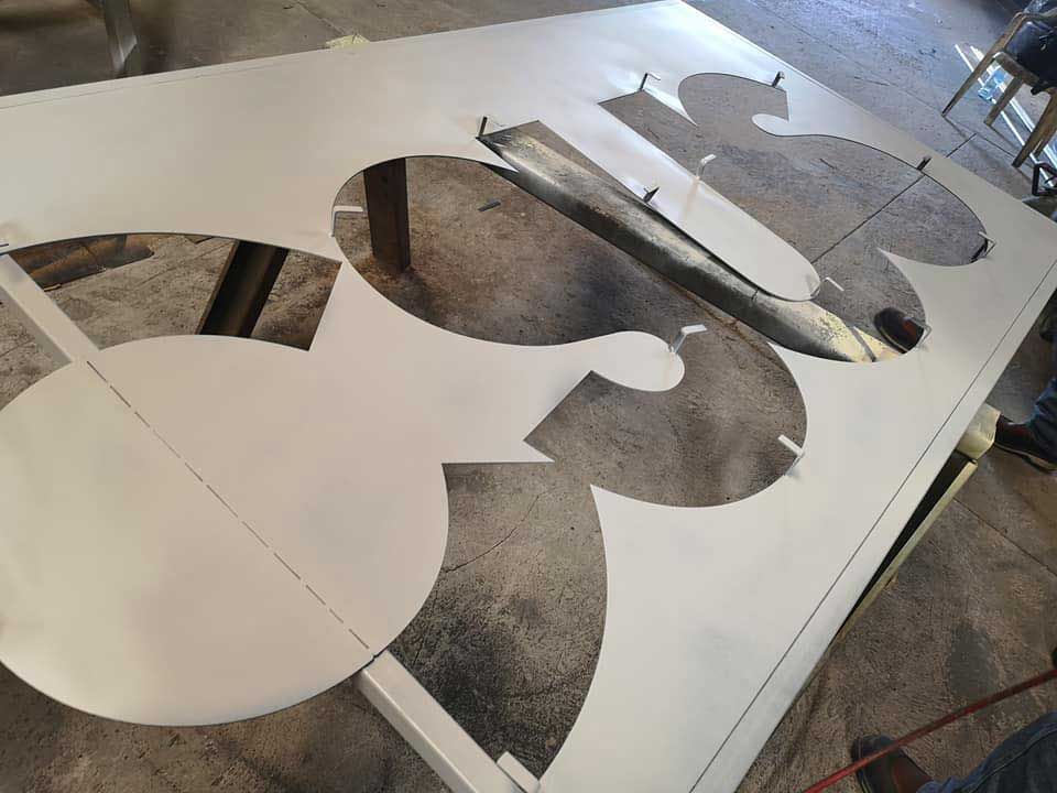 Un gran trozo de metal con una mariposa recortada en él.