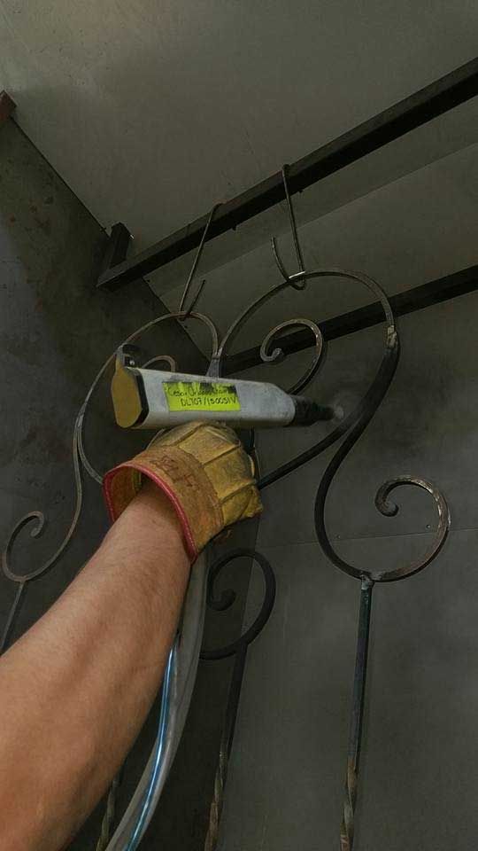 Una persona está trabajando en una barandilla de hierro forjado con un nivel.