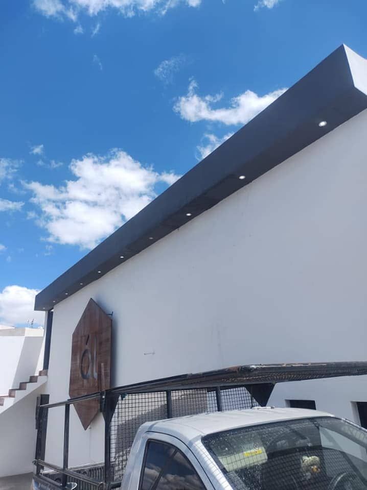 Un camión blanco está estacionado frente a un edificio blanco.