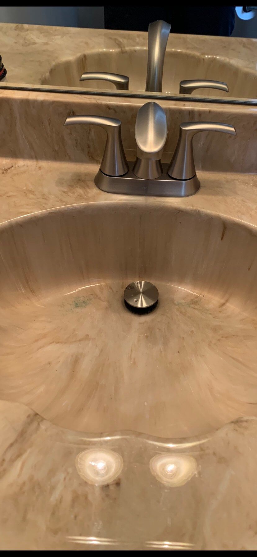 A bathroom sink with a faucet and a mirror.