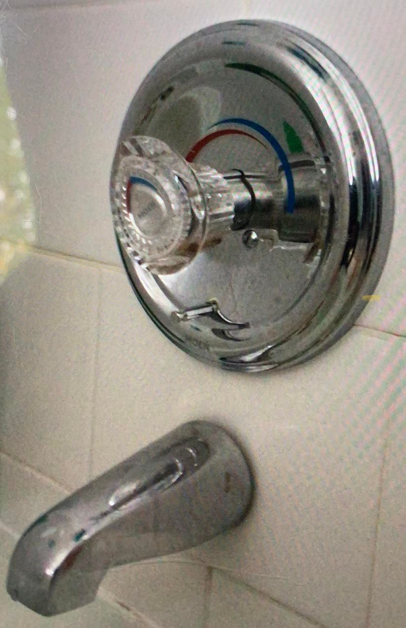 A chrome bathtub faucet with a clear handle