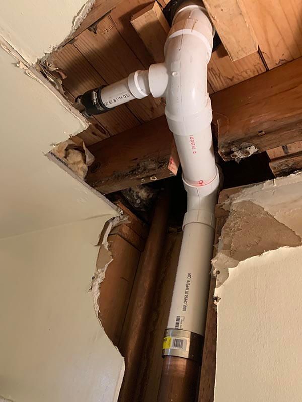 A pipe is coming out of a hole in the wall.