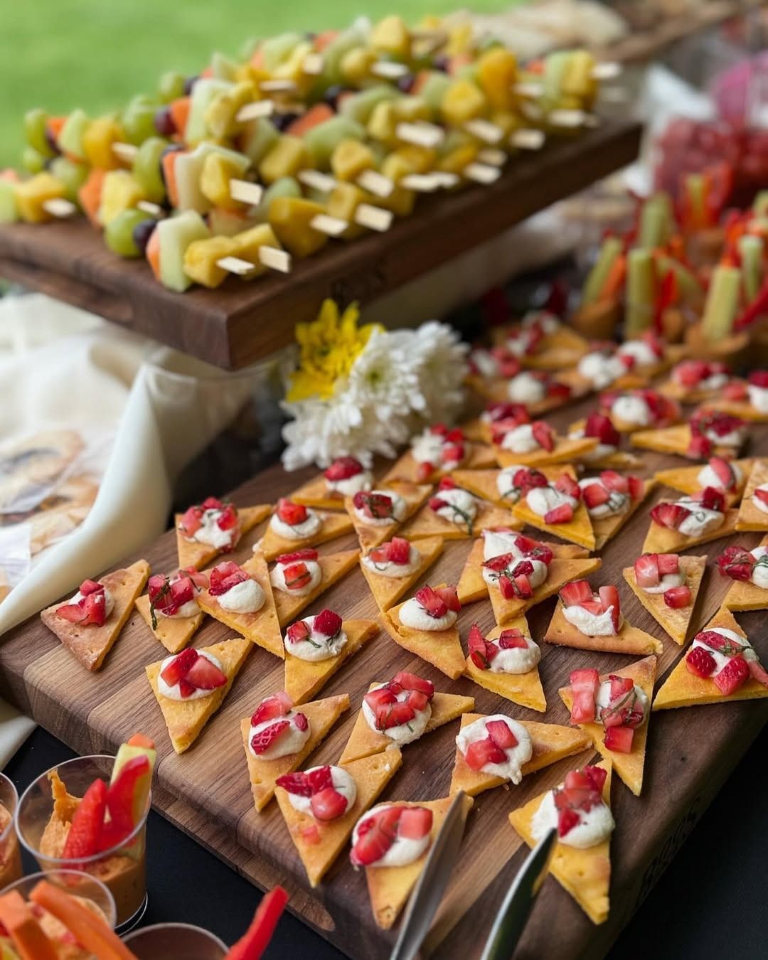A wooden cutting board topped with a variety of appetizers.