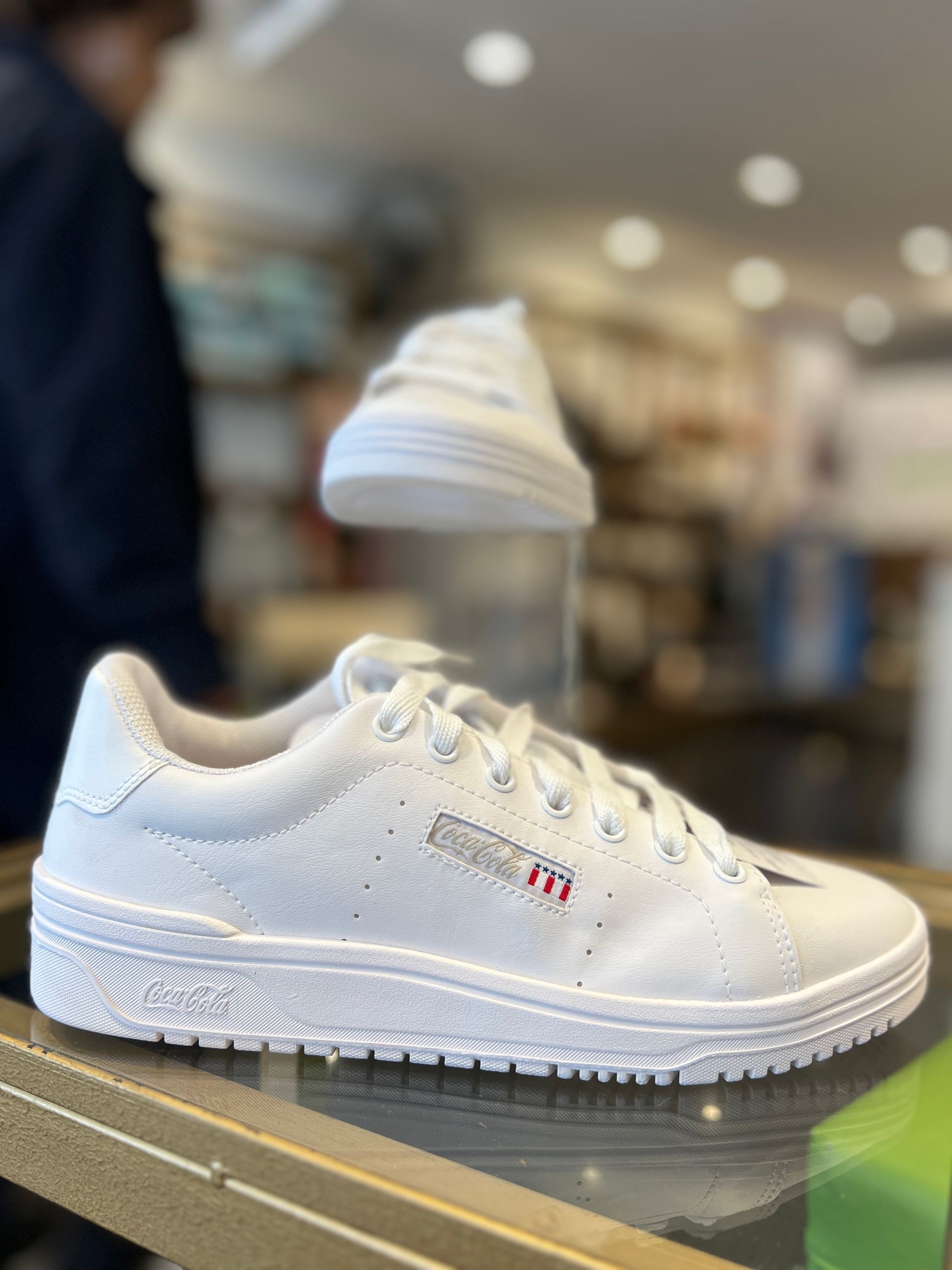 Un par de zapatillas blancas están sobre una mesa en una tienda.