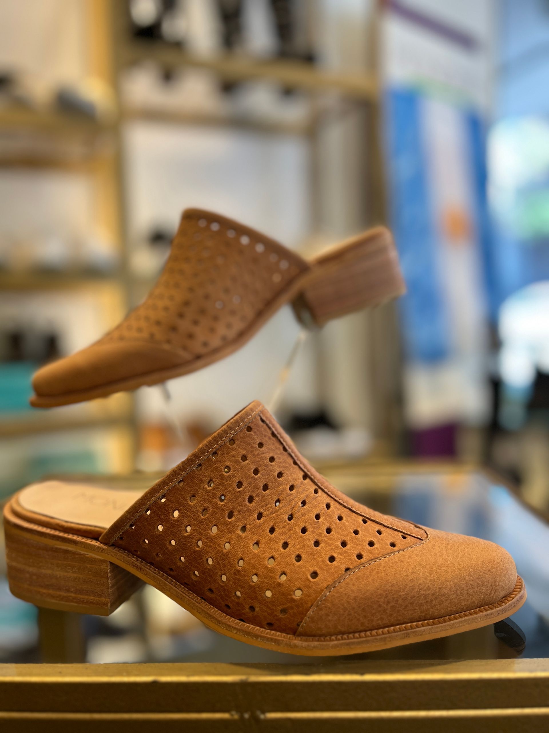 Un par de zapatos marrones están sobre una mesa en una tienda.