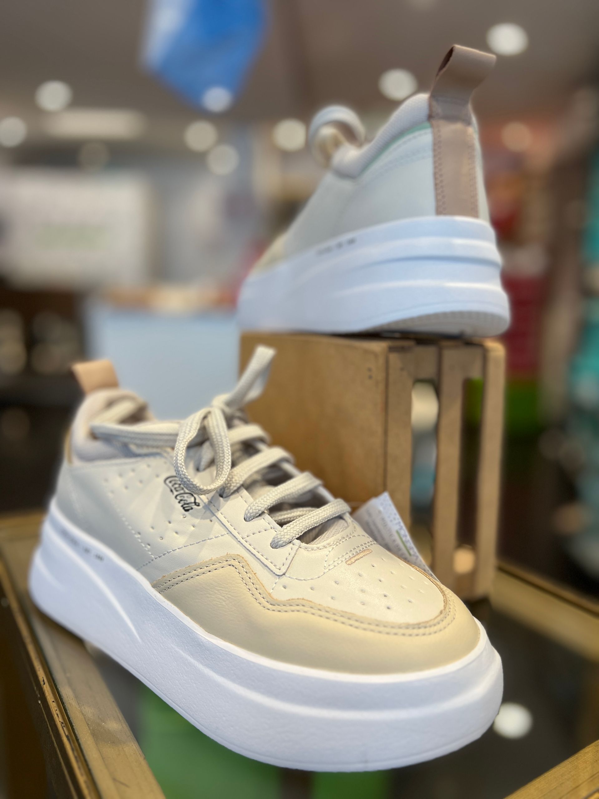 Un par de zapatillas blancas encima de una caja de madera.