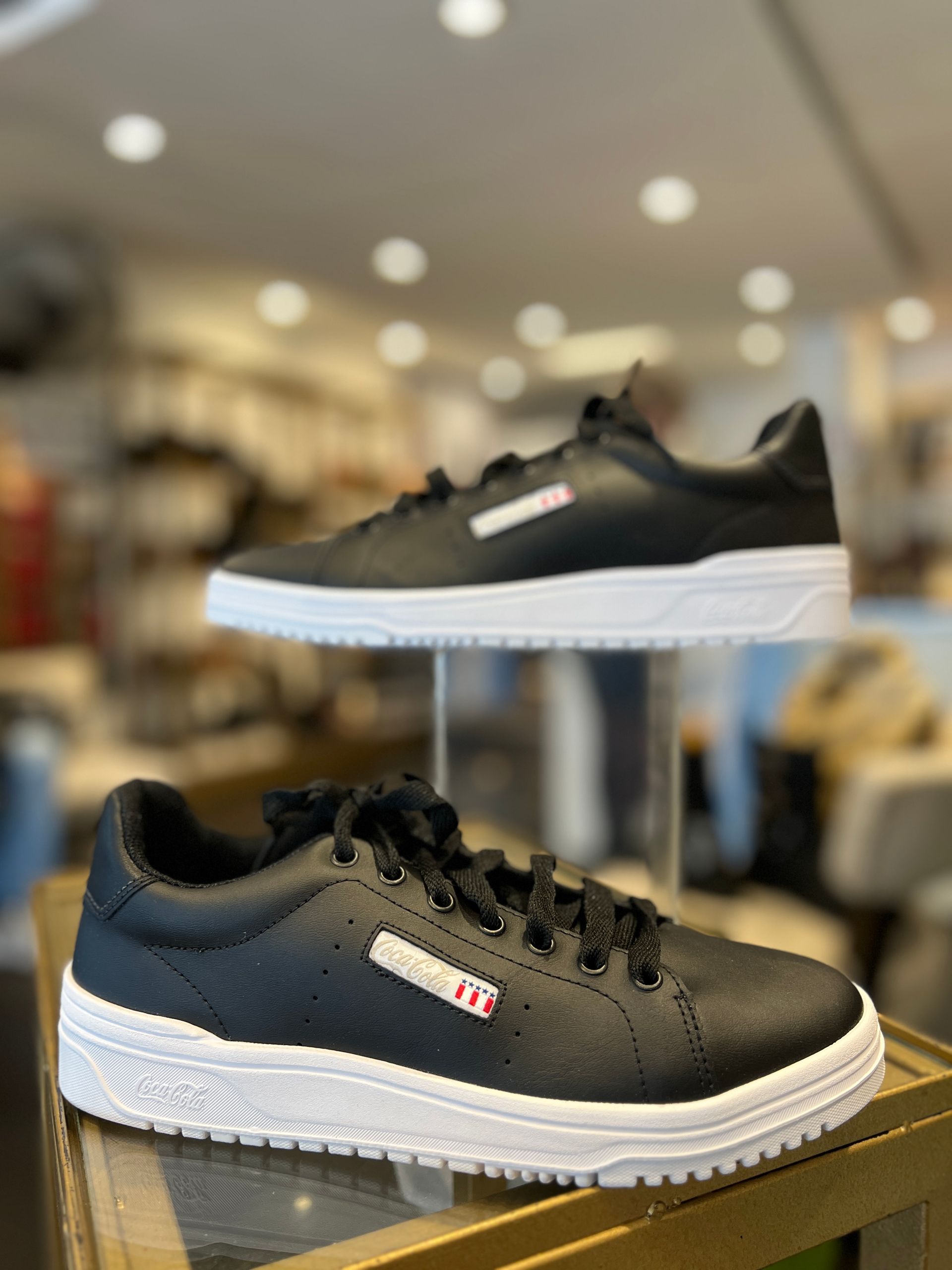 Un par de zapatillas blancas y negras en exhibición en una tienda.
