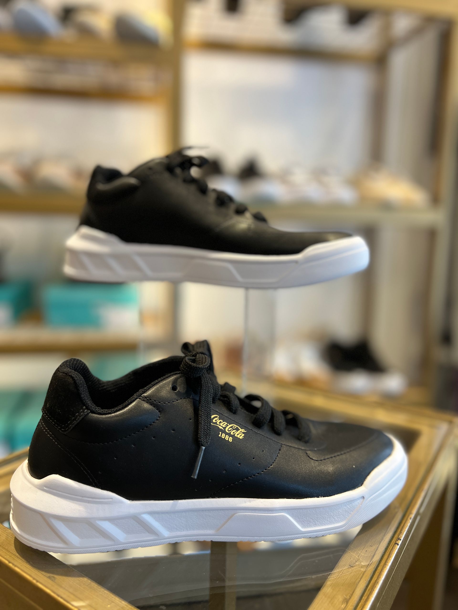 Un par de zapatillas blancas y negras están encima de una mesa de madera.