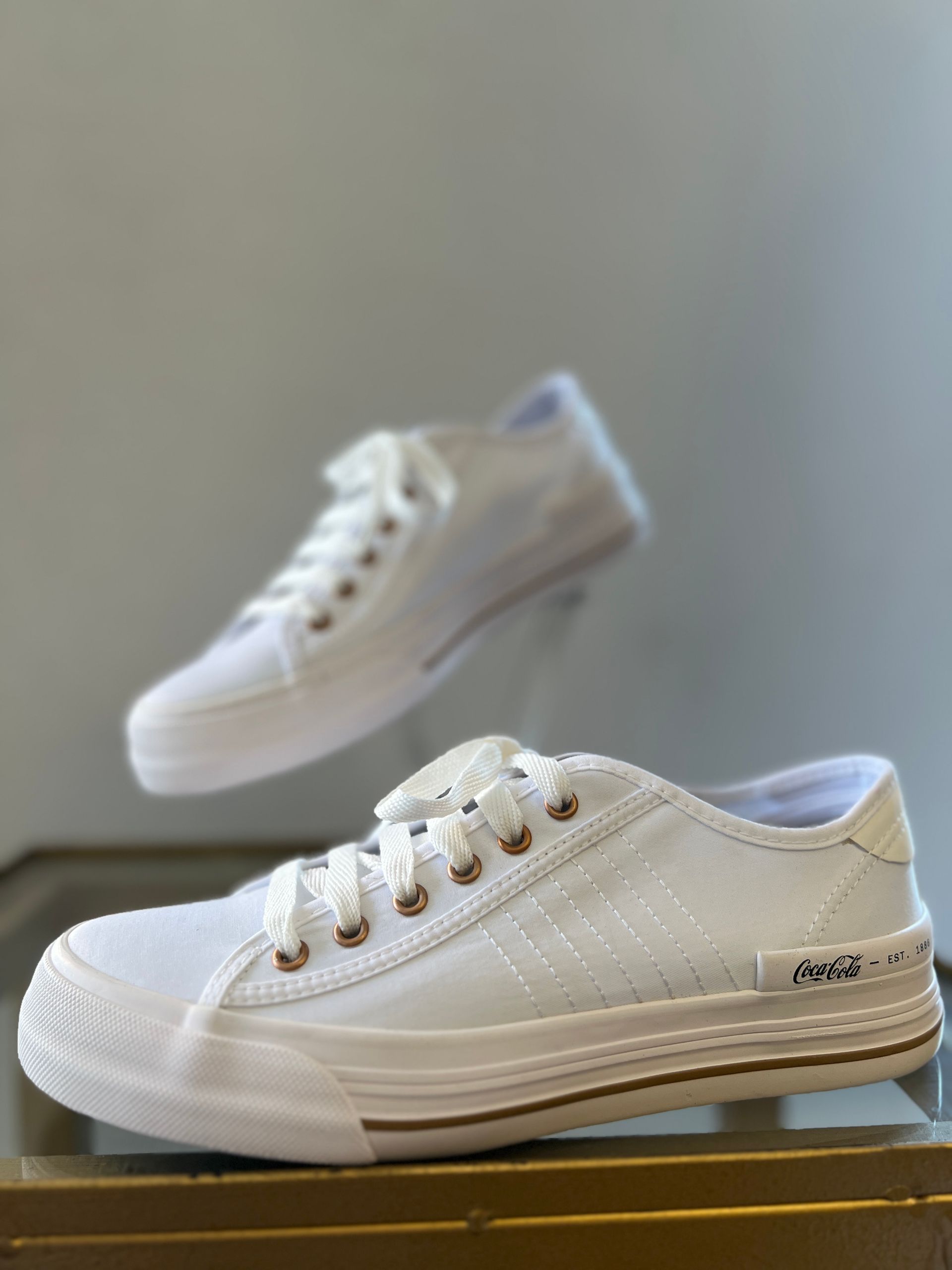 Un par de zapatillas blancas están encima de una mesa.