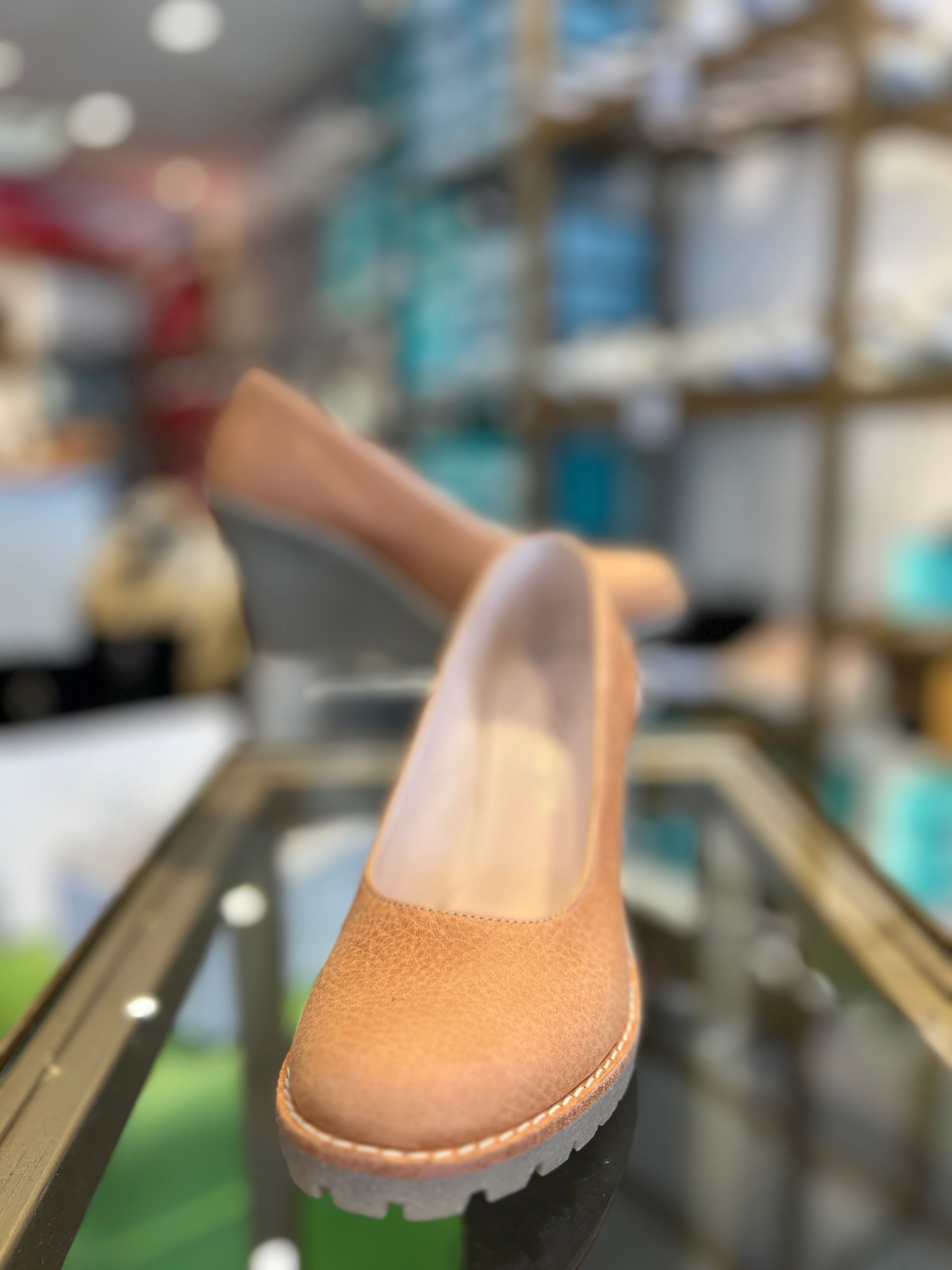 Un par de zapatos marrones sobre una mesa de cristal.