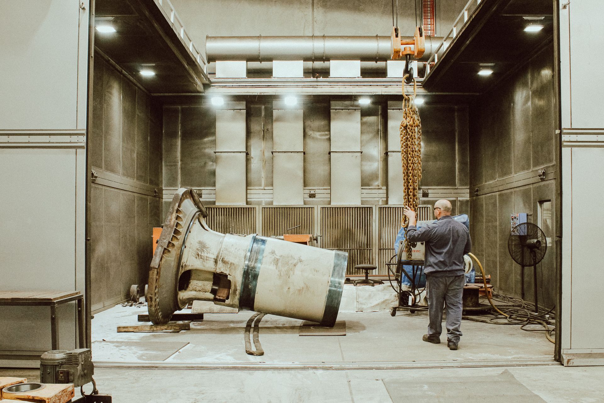 A man conducts quality control in a spacious industrial facility at New Metal Surfaces in Perth.