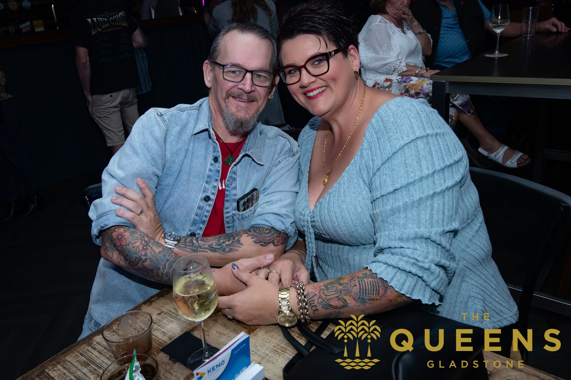 Two people smiling and holding a large fish at a Queens Slapfish event