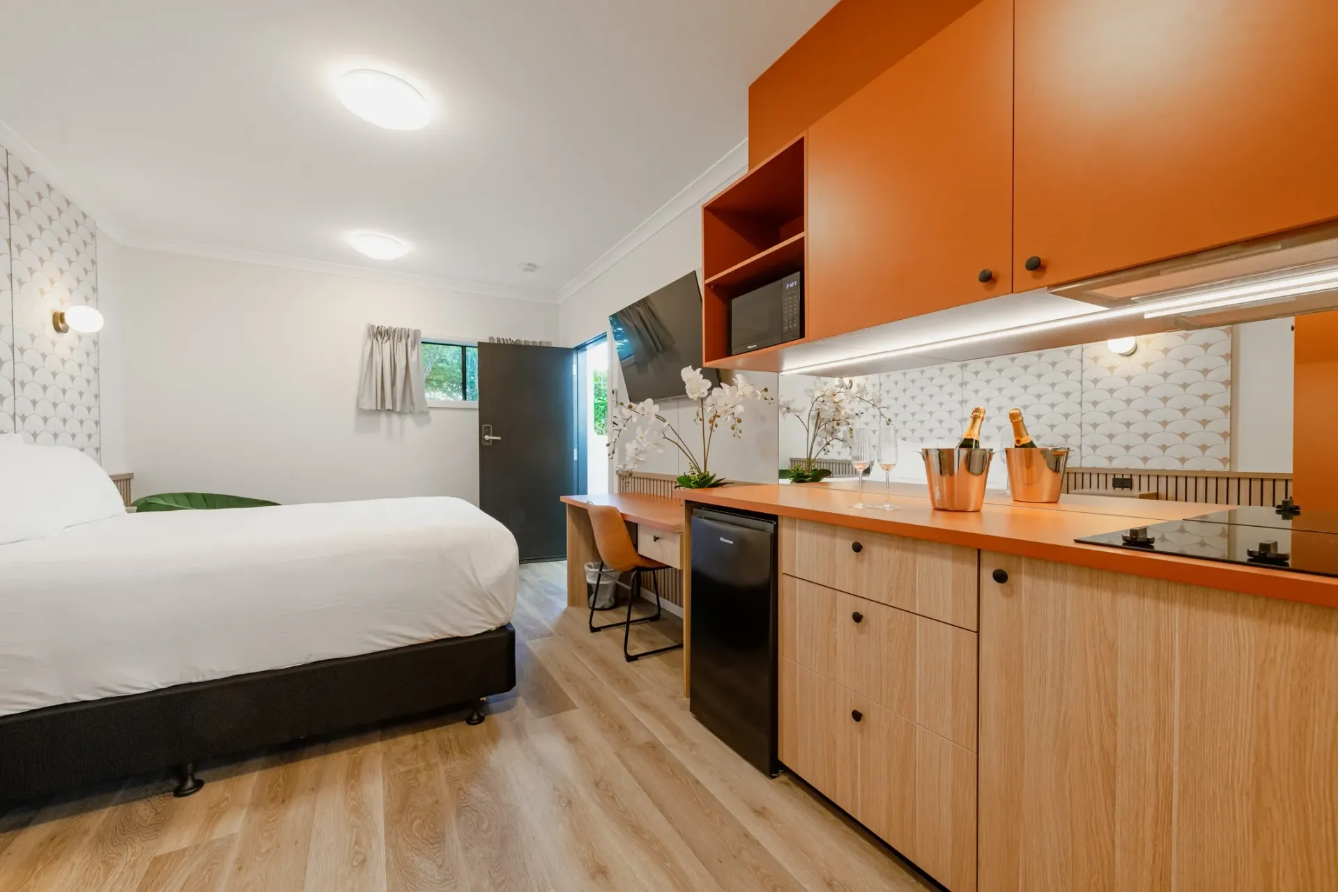 A bedroom with a king size bed and a kitchen.