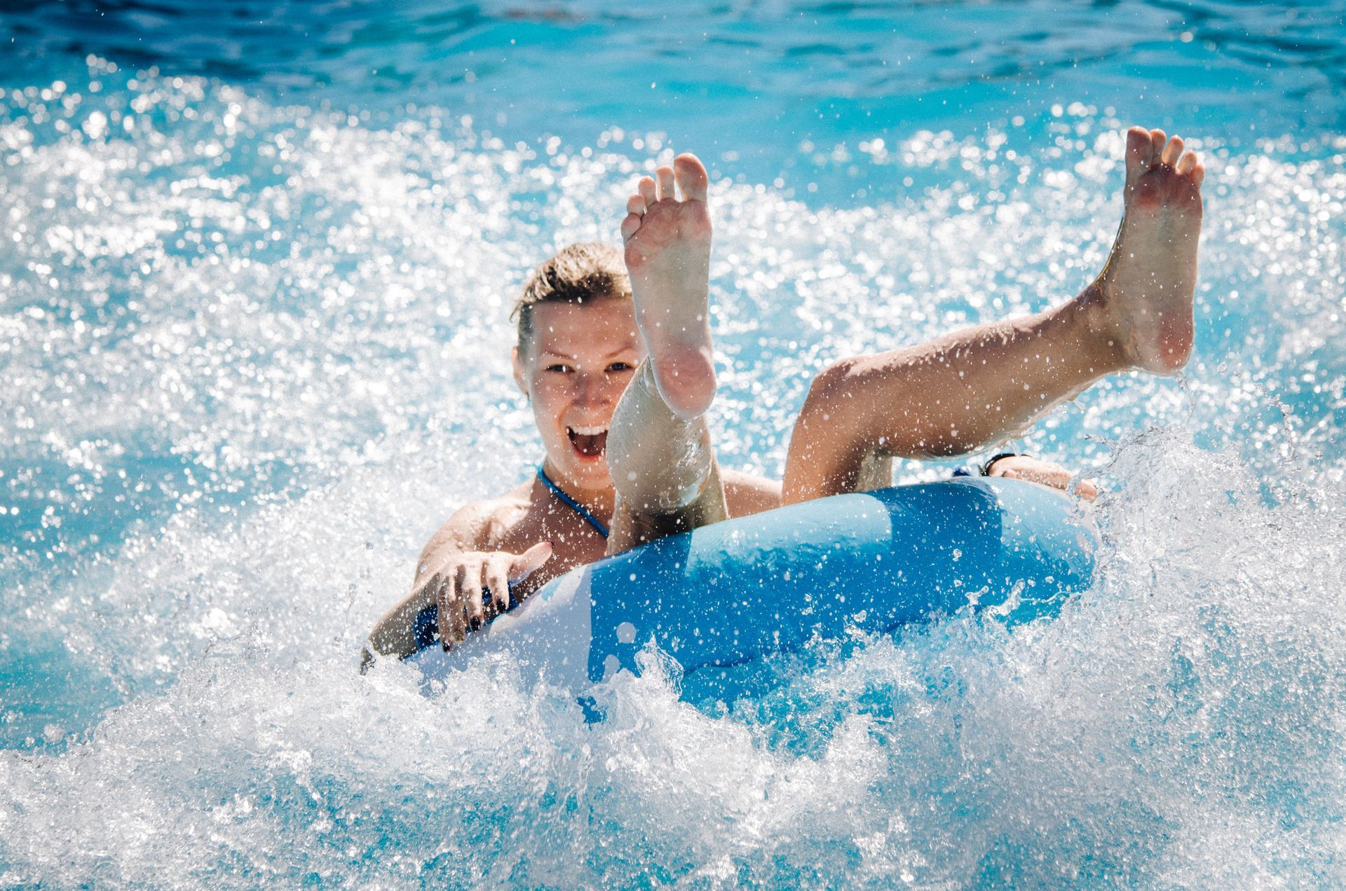 A woman is riding a tube in a swimming pool.