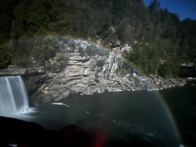 A waterfall with a rainbow in the background