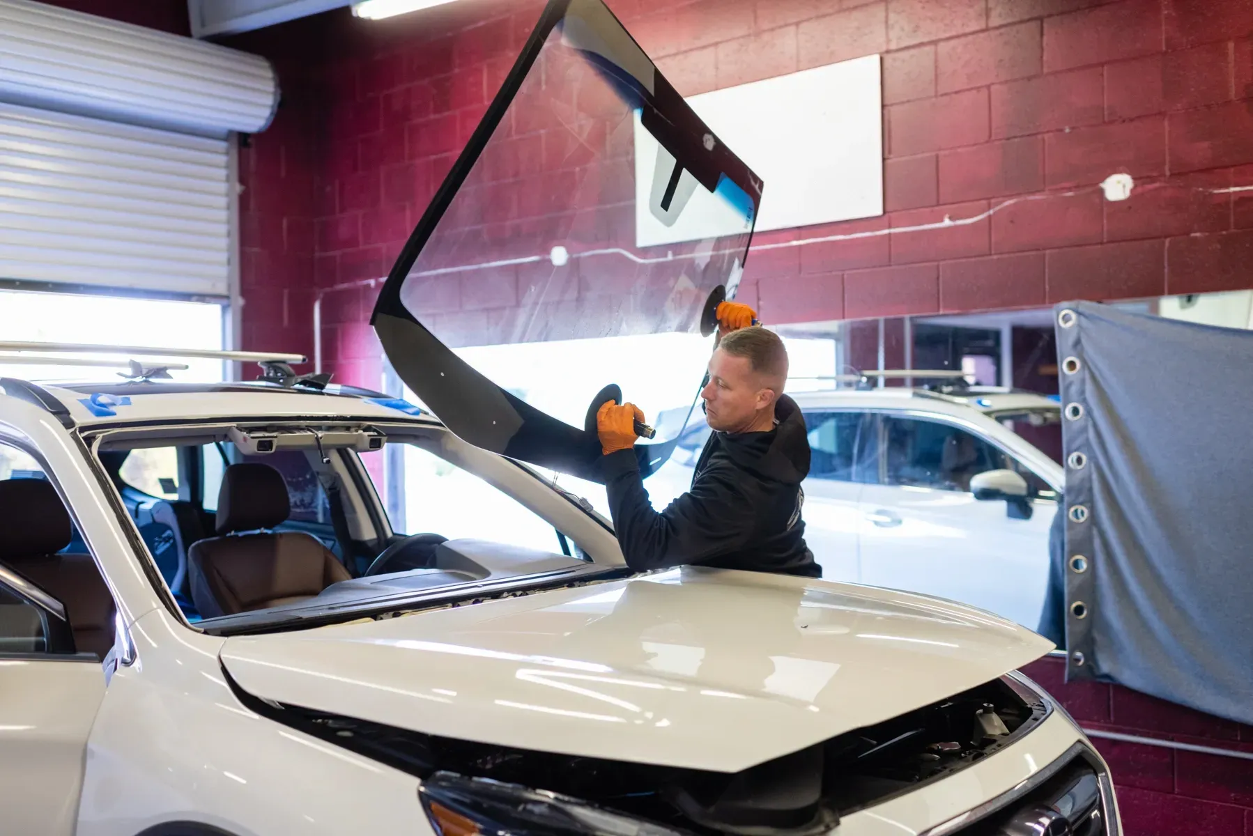 Windshield Replacement technician lifting widnshield