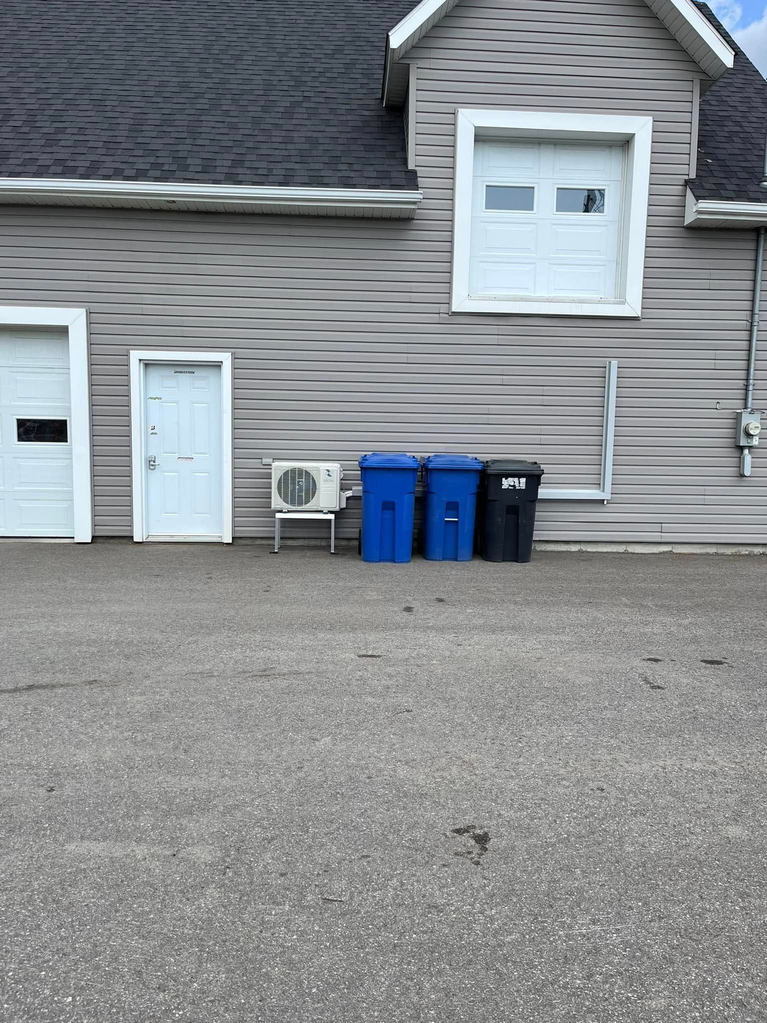Une maison avec beaucoup de poubelles devant