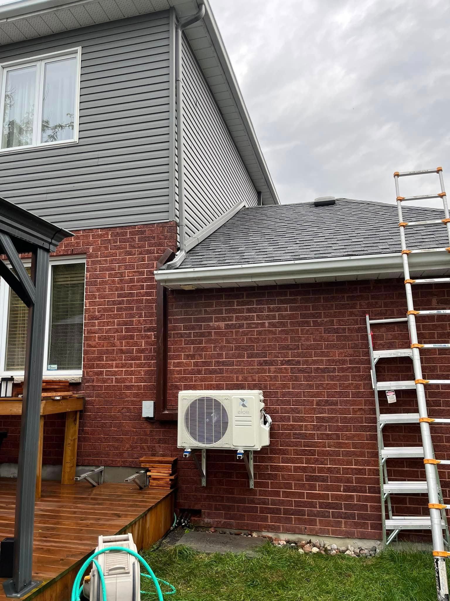 Une échelle est posée sur le côté d'une maison en briques.