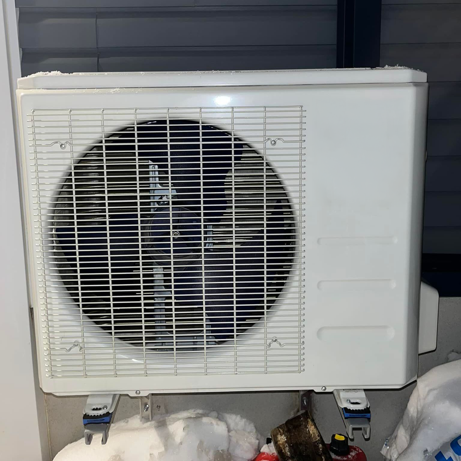 Un climatiseur blanc est posé sur le côté d'un bâtiment.