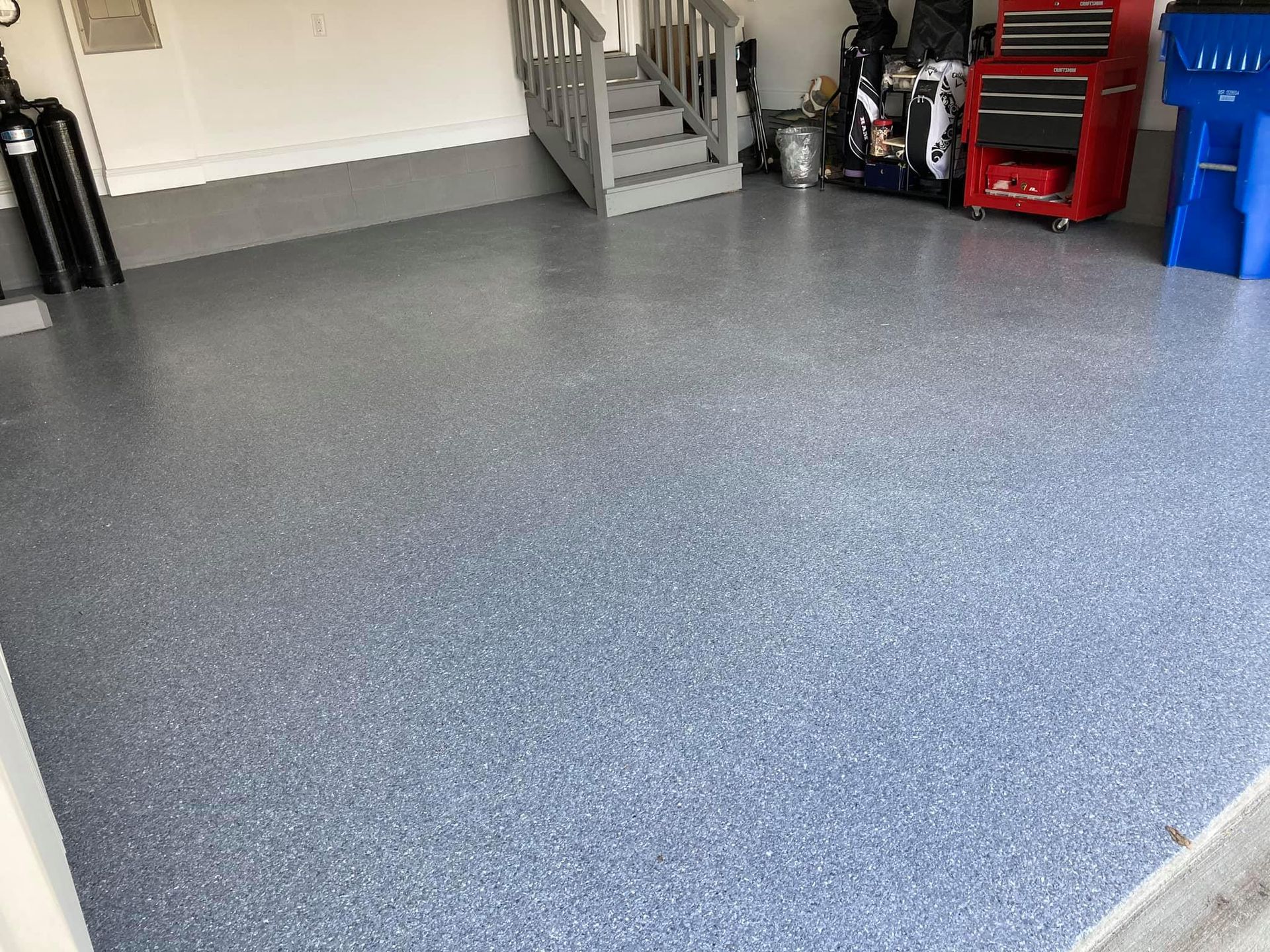 Garage with gray and blue speckled epoxy floor.