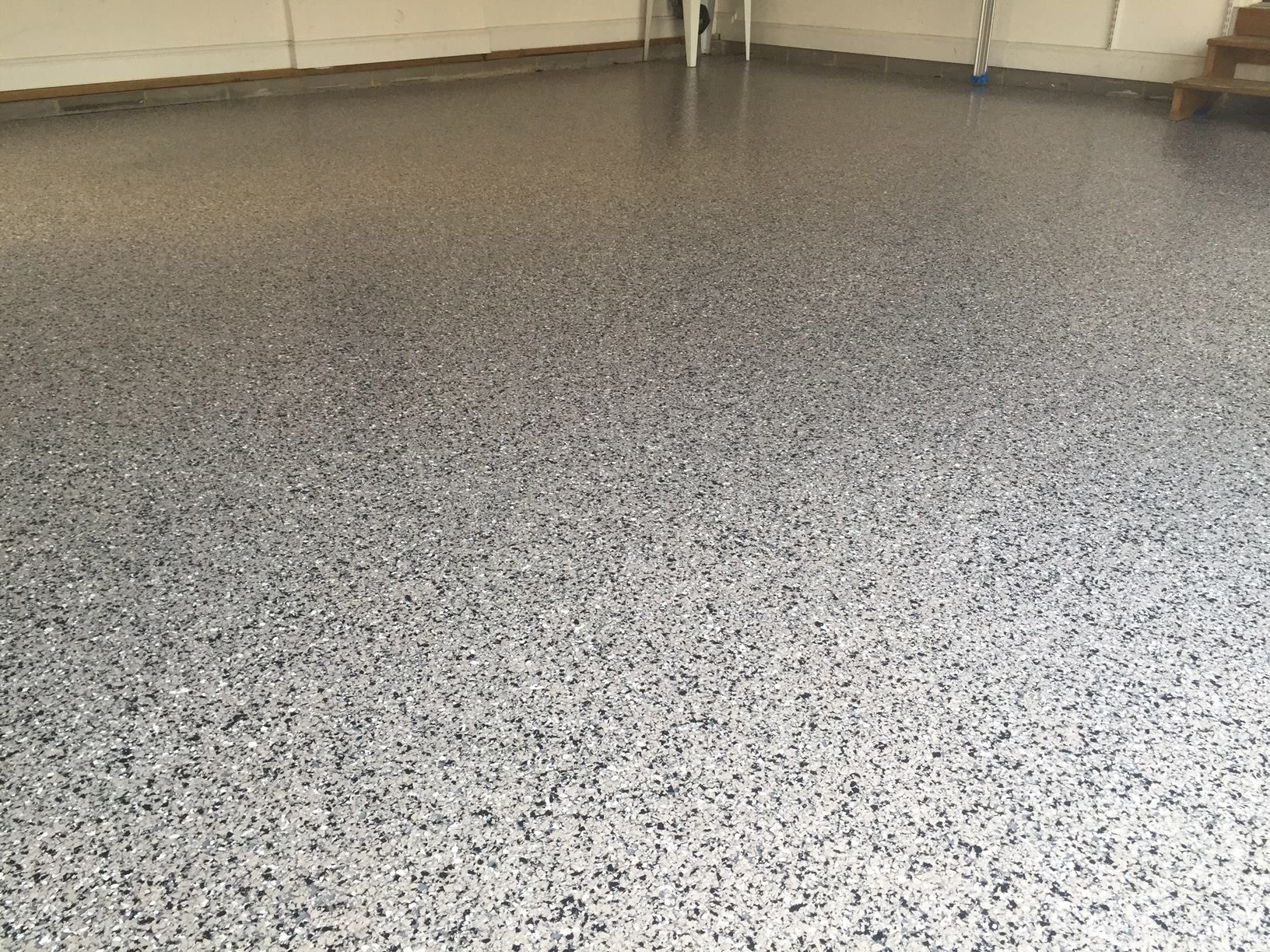 Epoxy garage floor speckled with gray, black, and white chips.