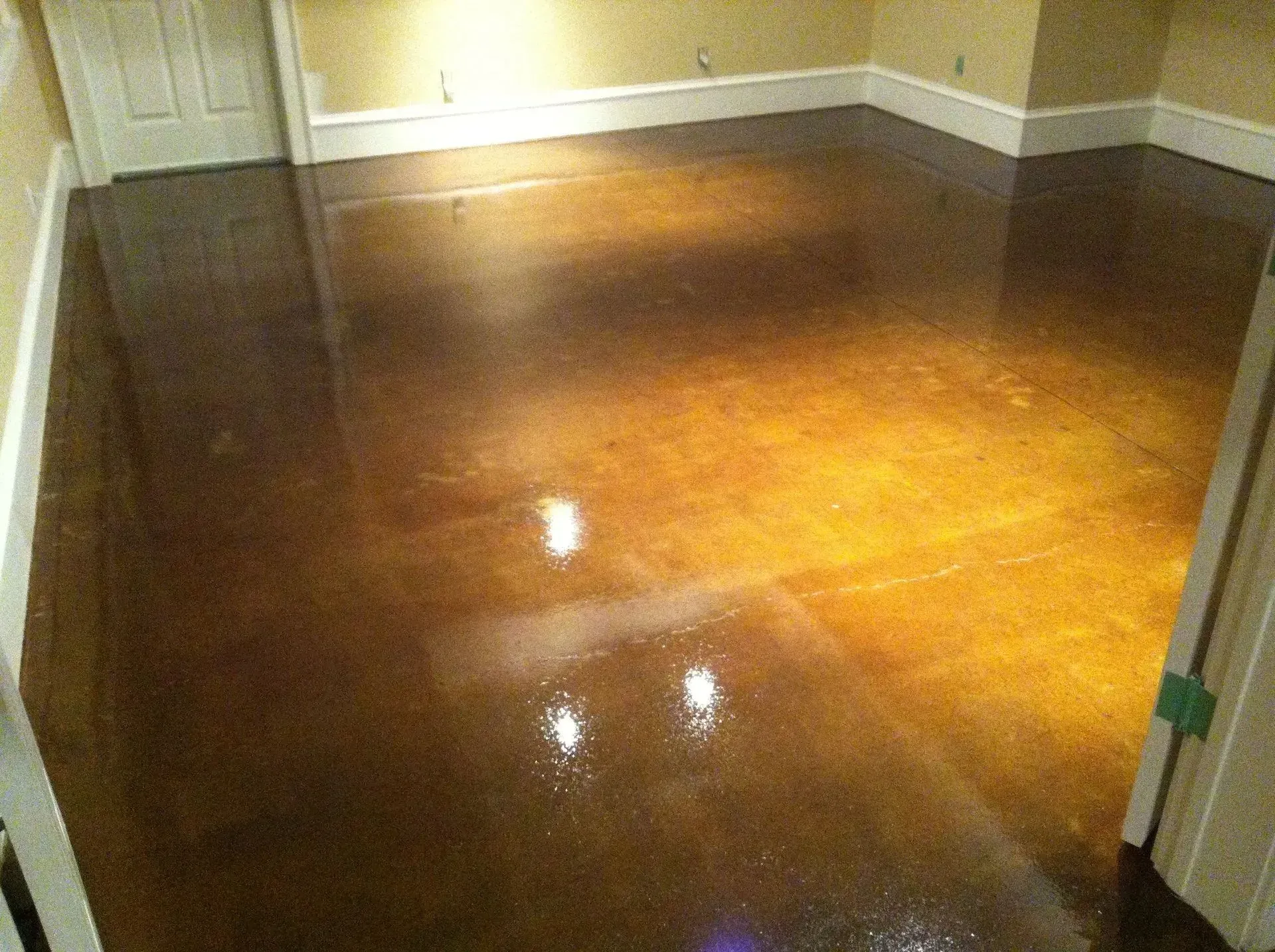 Polished concrete floor with a glossy, reflective surface; shades of brown and gold.