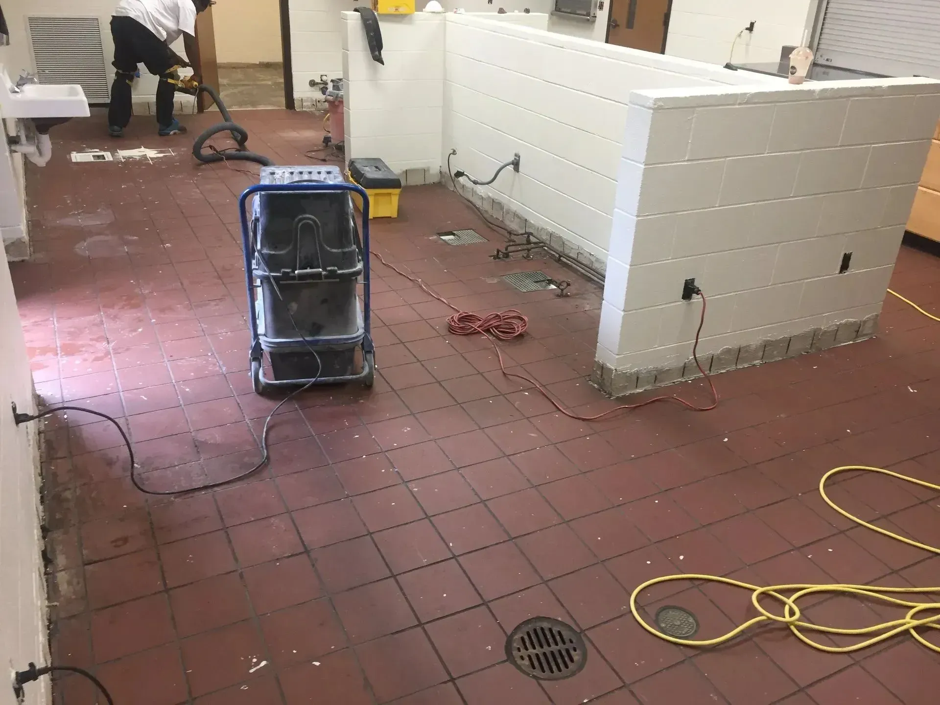 Room with red-tiled floor undergoing renovation.