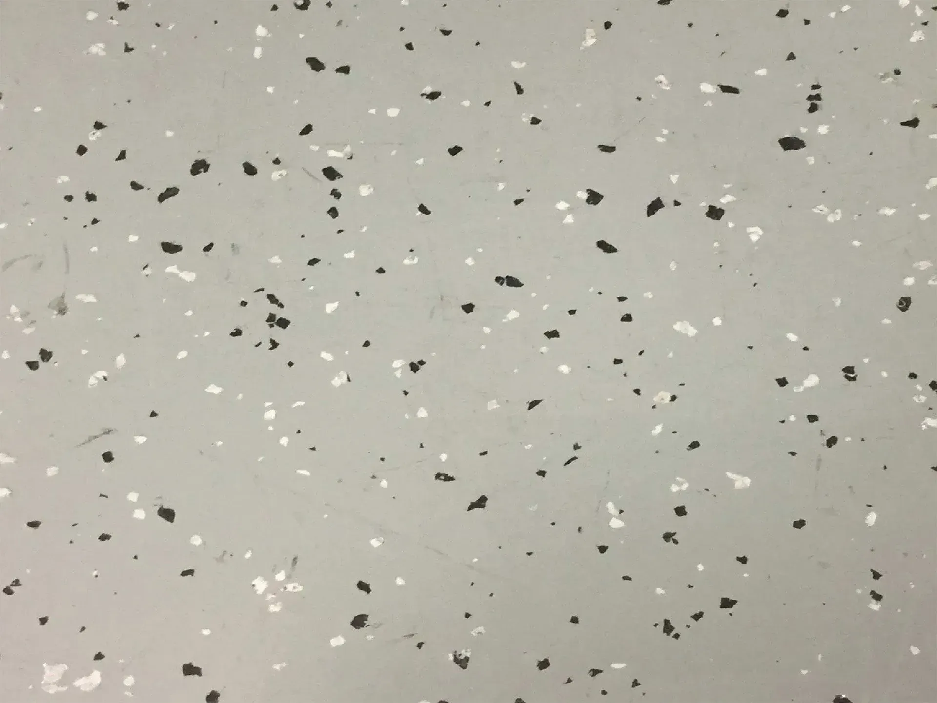 Gray flooring with scattered black and white flecks.