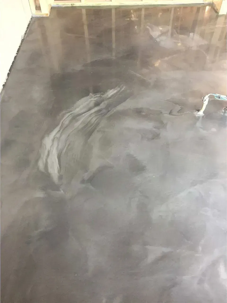 Metallic gray epoxy floor with swirling patterns.