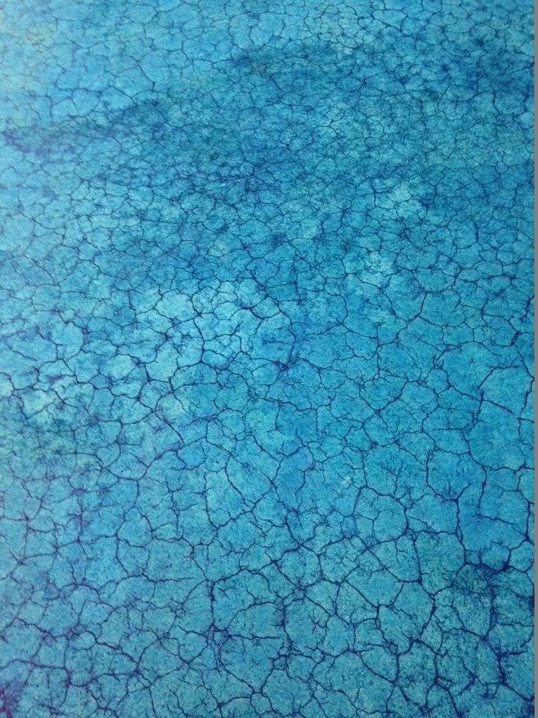 Blue cracked surface, resembling dry earth.