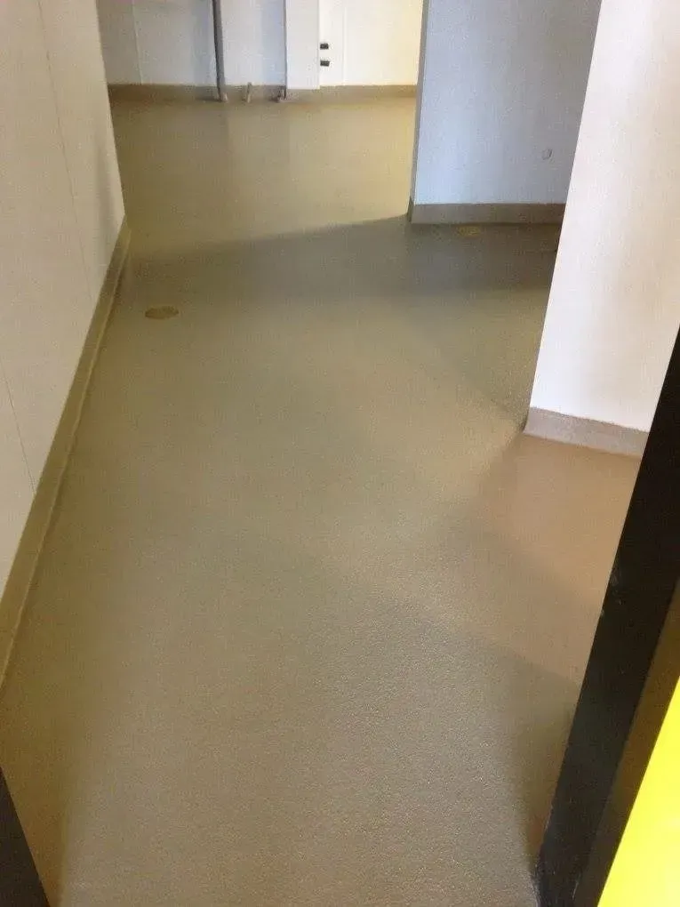 Narrow hallway with light brown floor and white walls.