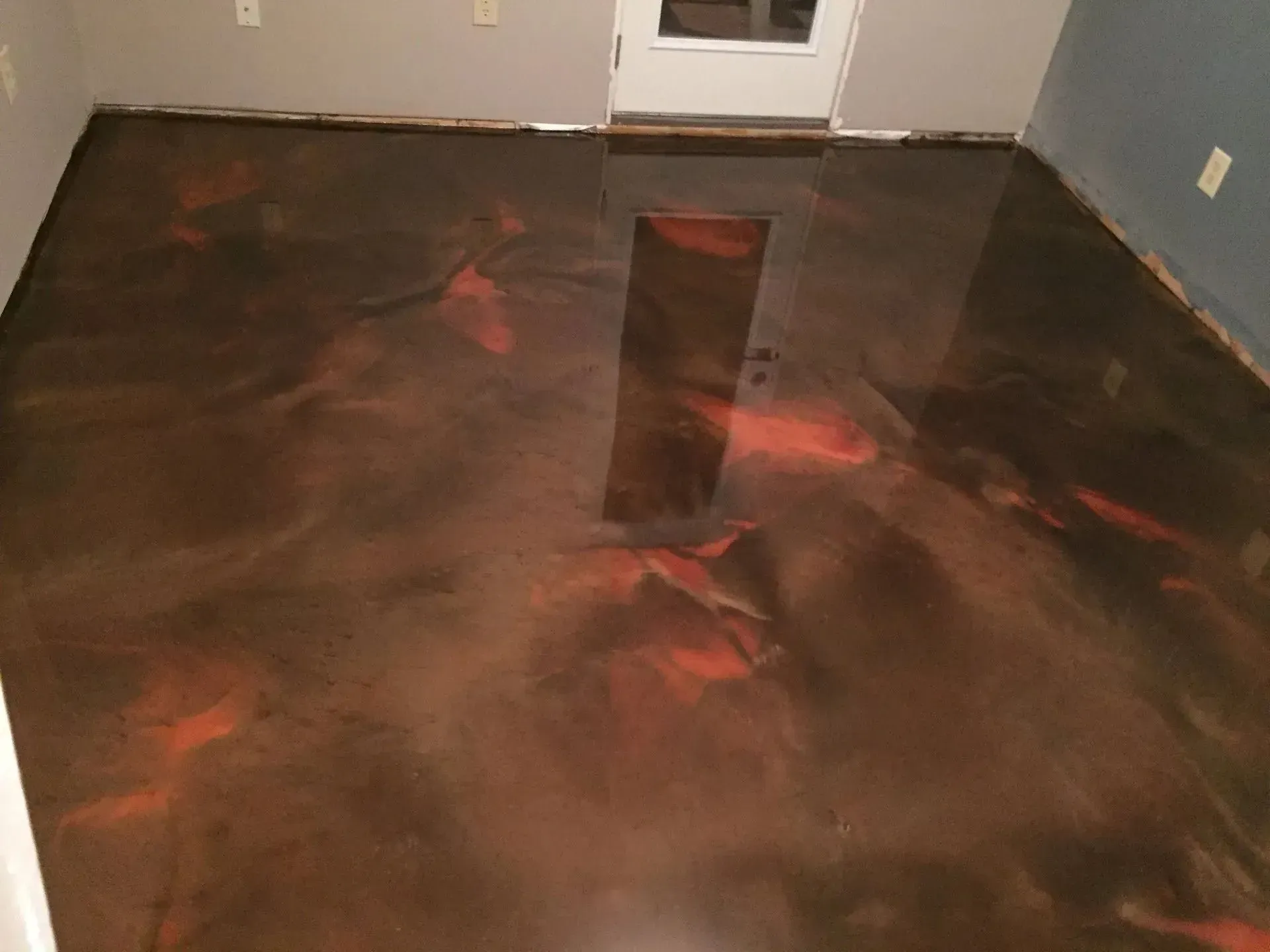 Metallic epoxy floor in shades of brown and red, with a glossy finish.