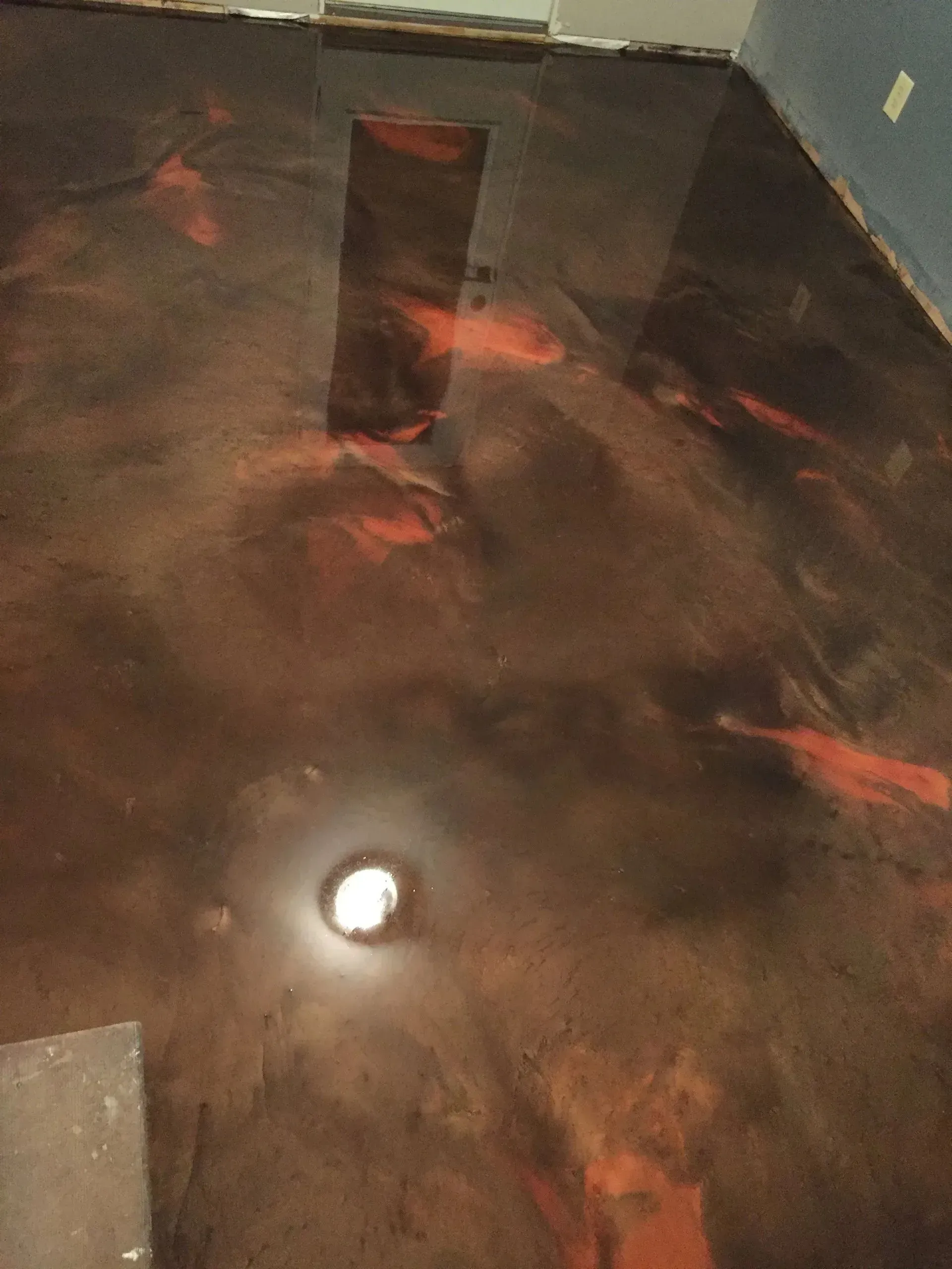 Metallic epoxy floor with shades of brown and red; glossy finish.