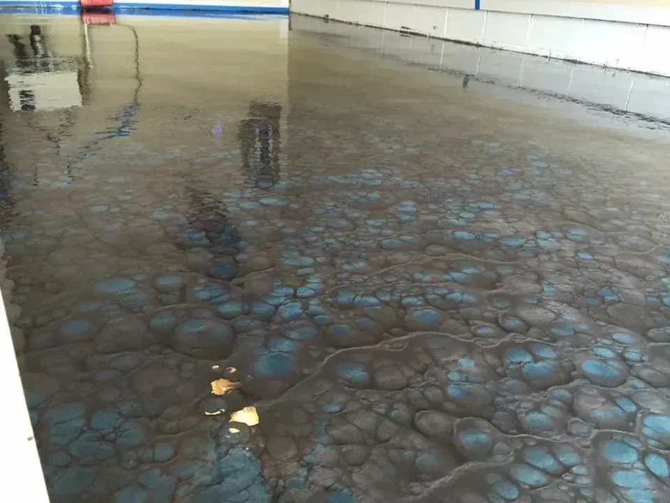 Shiny, mottled floor with blue and brown patterns, reflecting surroundings.
