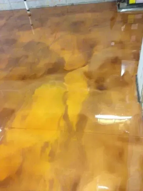 Metallic epoxy flooring in shades of gold and brown, with a glossy finish.