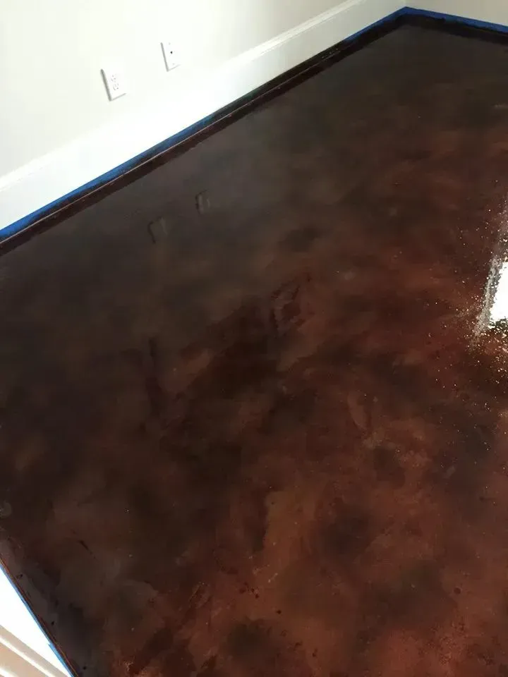 Brown metallic epoxy flooring with highlights and tape along the edges.