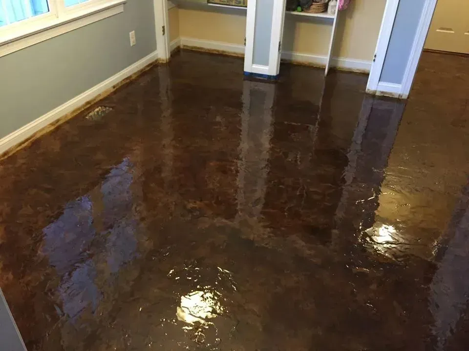 Brown, glossy floor with marbled effect in a room with white trim, a window, and light gray walls.
