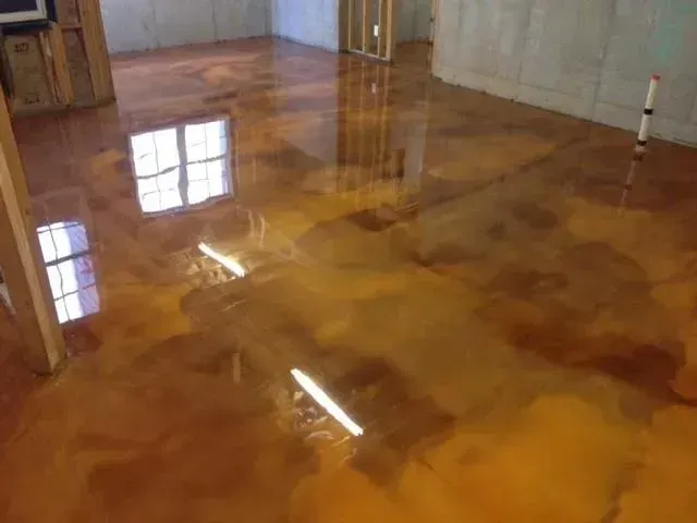 Golden epoxy floor in a room, reflecting light from windows and walls.