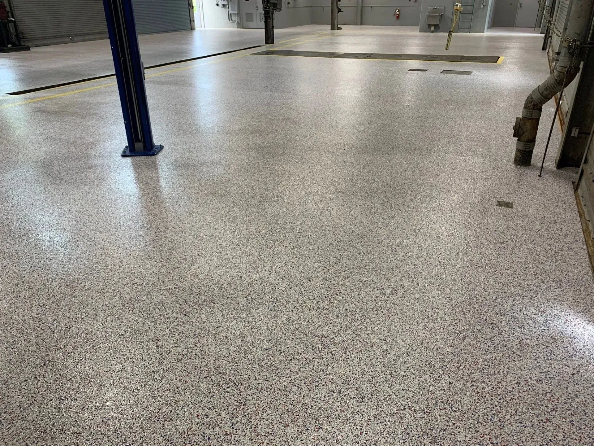 Polished concrete floor with speckled light and dark aggregate in a garage.