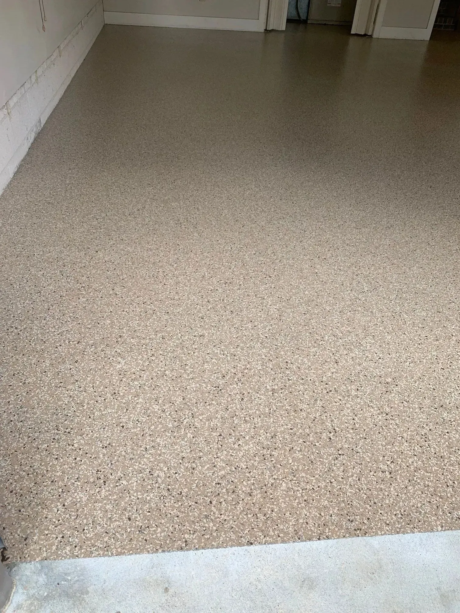 Tan speckled epoxy floor in a garage.