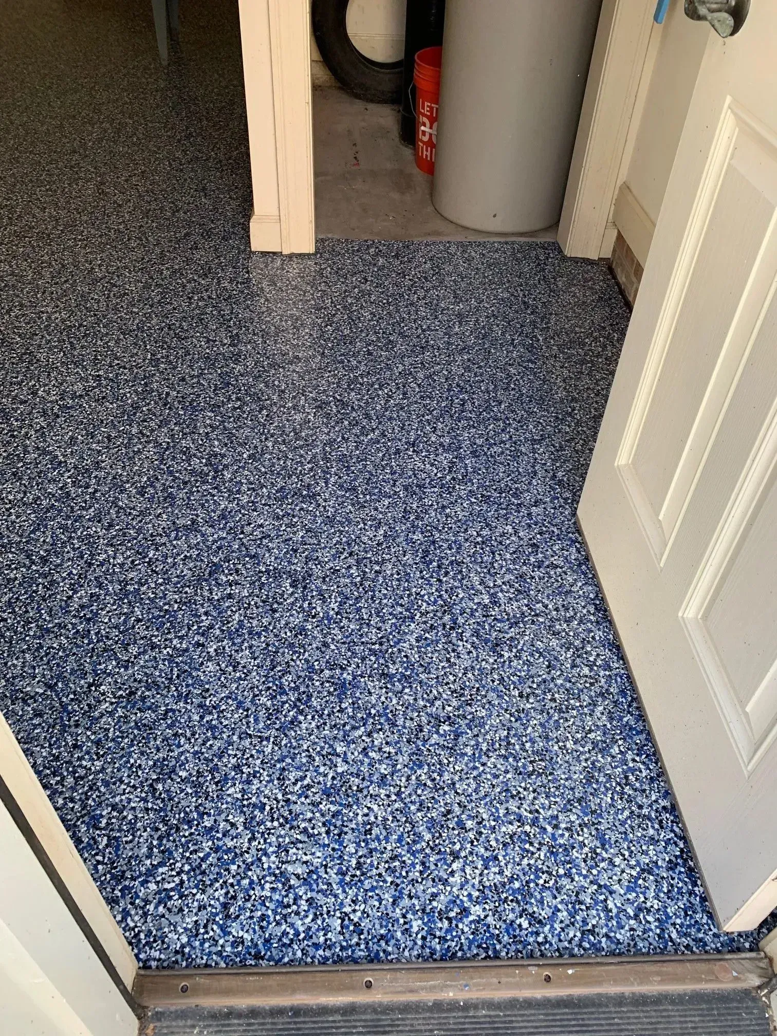 Blue speckled epoxy garage floor, seen from doorway.