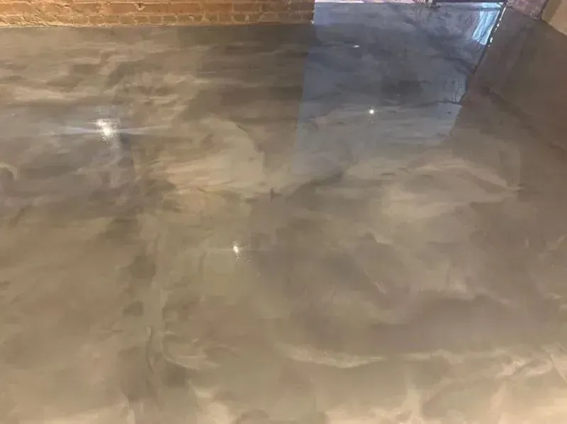 Metallic, silver-gray epoxy floor with swirling patterns reflecting light.