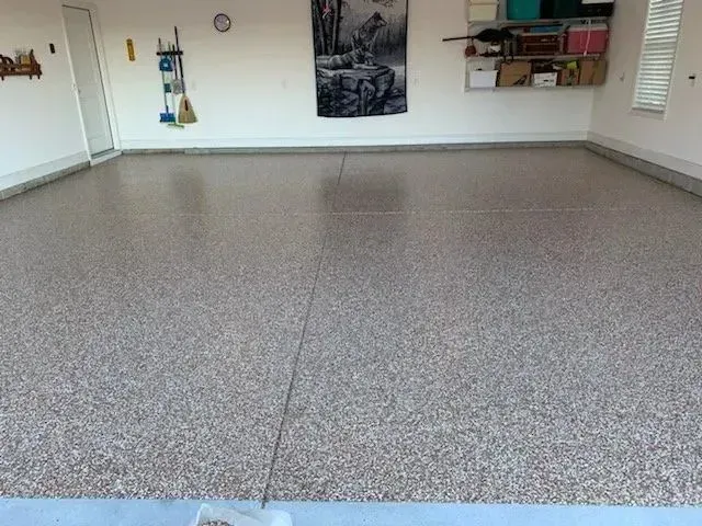 Finished garage floor with decorative chips and a shiny coating.
