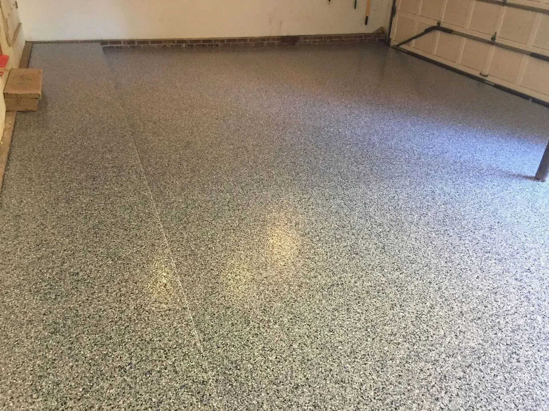 Epoxy garage floor speckled with gray, black, and white chips.